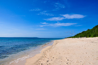 Scenic view of beach against blue sky