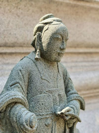 Close-up of buddha statue against wall