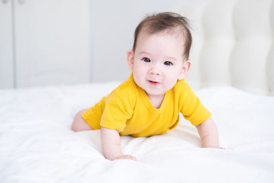 Cute baby boy sleeping on bed at home