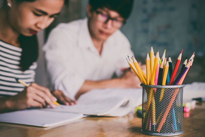 Students studying at table in classroom