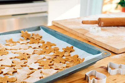 Baking sheet with christmas gingerbread cookies a shape of gingerbread man, christmas tree and star