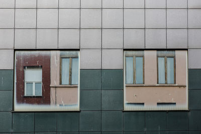 Two large windows reflect the facade on the opposite side