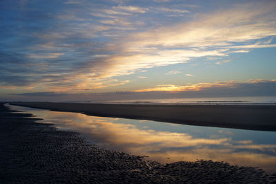 Scenic view of lake against sky at sunset