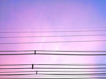 Low angle view of power lines against sky