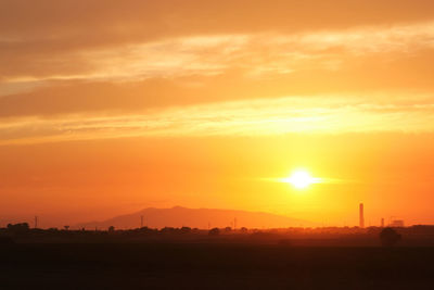 Scenic view of silhouette field against romantic sky at sunset