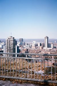 High angle view of railroad tracks by buildings against clear sky