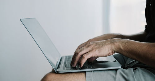 Midsection of man using laptop