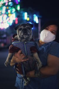 Midsection of woman holding dog at home