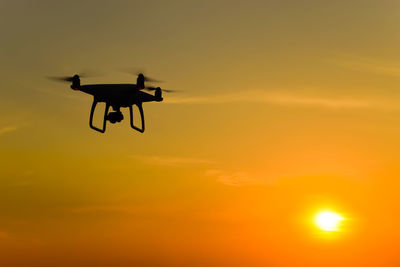 Low angle view of silhouette airplane against sky during sunset