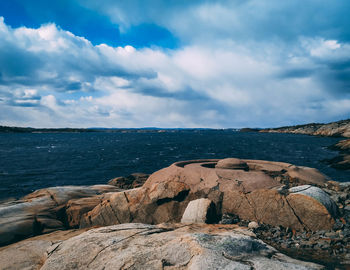 Scenic view of rocks on beach against sky