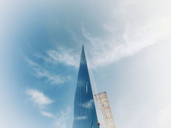 Low angle view of buildings against cloudy sky