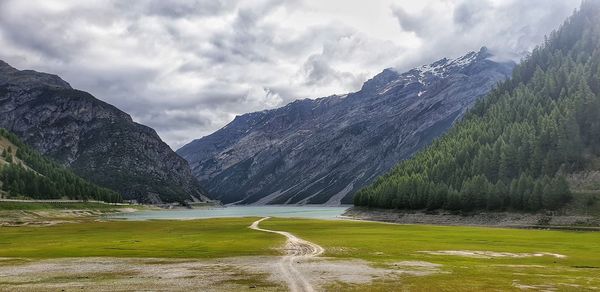 Scenic view of lake by mountains against sky