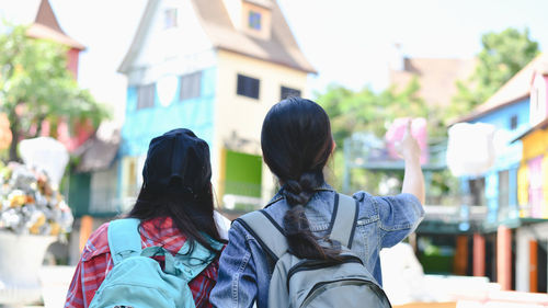 Rear view of women standing outdoors