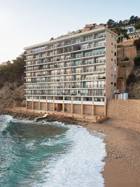 Exterior of building by sea against sky