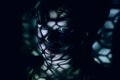 Close-up portrait of serious woman with shadow in darkroom