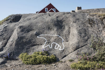 Text on rock against sky