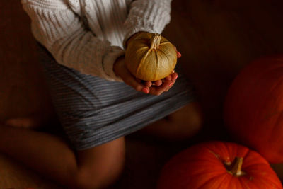 High angle view of woman holding pumpkin