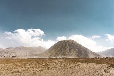 View of volcanic landscape against cloudy sky