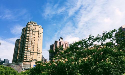 Low angle view of buildings against cloudy sky