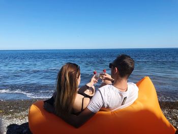 People photographing sea against sky