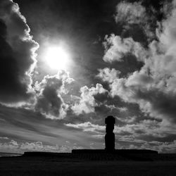 Silhouette built structure on field against sky