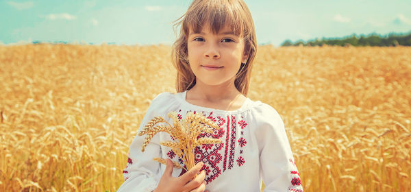 Portrait of young woman standing amidst plants