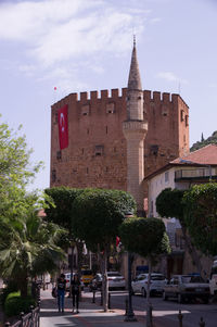 Road by building in city against sky