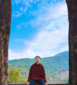 Portrait of man standing on mountain against sky