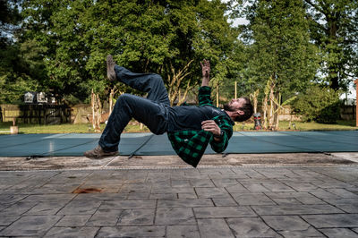 Young man jumping on footpath. backflip