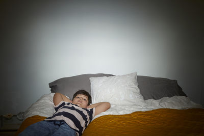 Portrait of boy lying on bed