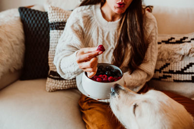 Midsection of woman holding bowl at home