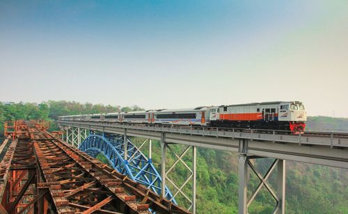 Train on bridge against clear sky