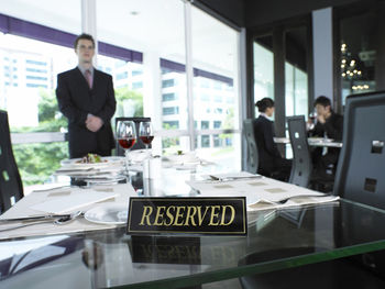Close-up of reserved sign on table at restaurant