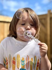 Close-up of boy blowing bubbles