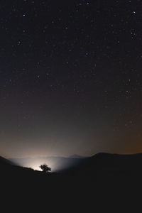 Scenic view of silhouette mountain against sky at night