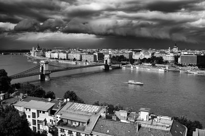 High angle view of buildings by river against sky