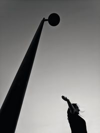 Low angle view of silhouette woman playing against clear sky