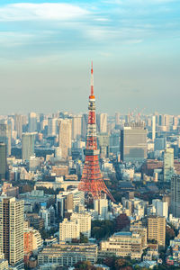 Aerial view of buildings in city against cloudy sky