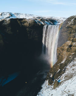 Scenic view of waterfall against sky