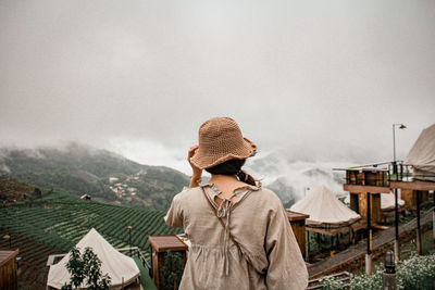 Rear view of woman standing against sky