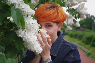 Portrait of woman holding flowering plant