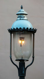 Close-up of illuminated lamp against wall