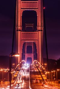 Traffic on illuminated bridge in city at night