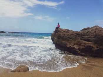 Scenic view of rocks on beach against sky
