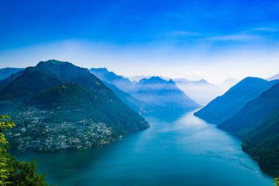 Scenic view of sea and mountains against blue sky