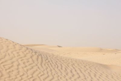 Scenic view of sand dunes against clear sky