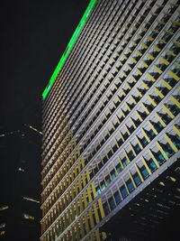 Low angle view of illuminated buildings against sky at night