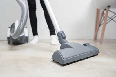 Woman using vacuum cleaner at the floor