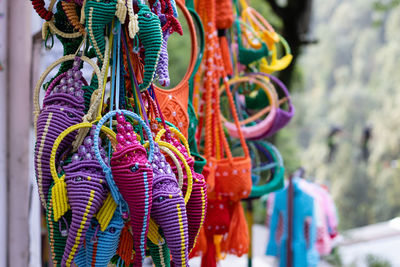 Selective focus on number of hand crafted colorful items hanging in an indian market shop