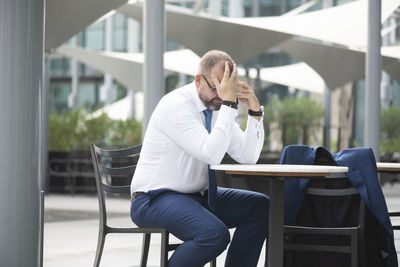 Man using mobile phone while sitting on chair